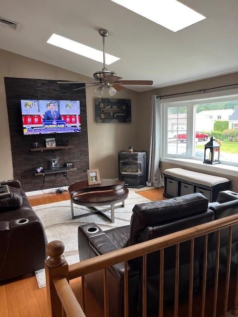 80 Capwell Ave, Woonsocket, RI 02895 - living area featuring a wood stove, light wood-style floors, a skylight, vaulted ceiling, and a ceiling fan
