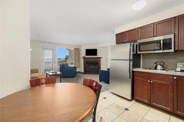 65 Ridge Rd Unit T11/W38, Newport, RI 02840 - kitchen with stainless steel appliances, a fireplace, light countertops, light tile patterned floors, and open floor plan