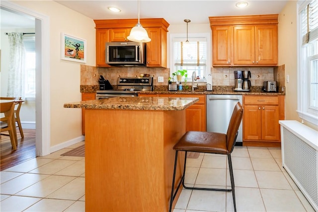 59 Davis Ave, Cranston, RI 02910 - kitchen featuring stainless steel appliances, a kitchen island, decorative backsplash, a sink, and dark stone countertops