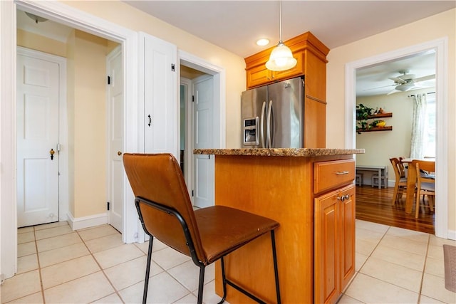 59 Davis Ave, Cranston, RI 02910 - kitchen featuring stainless steel fridge, light tile patterned floors, hanging light fixtures, and brown cabinets