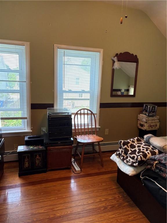 15 Villa Ave, Cranston, RI 02905 - living area with baseboard heating, wood finished floors, and vaulted ceiling