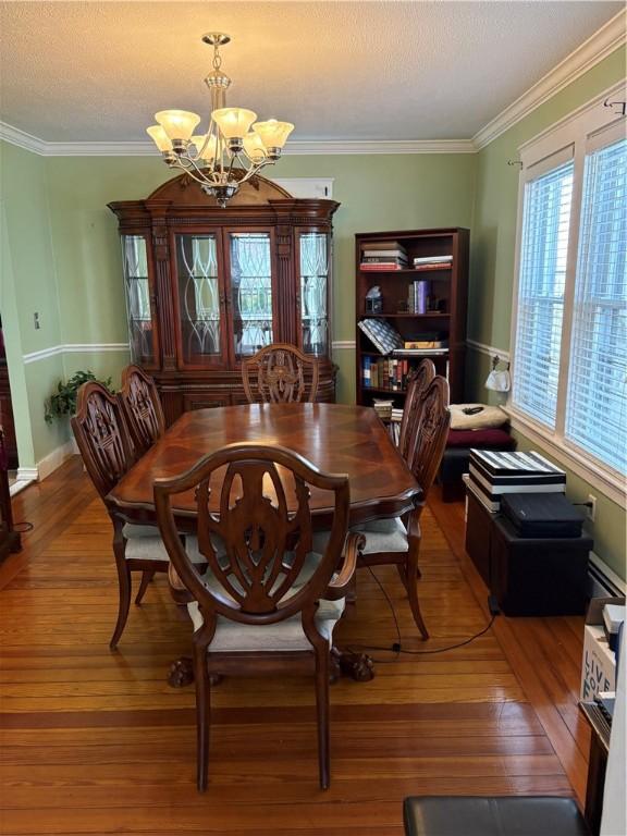 15 Villa Ave, Cranston, RI 02905 - dining space with a chandelier, wood finished floors, a baseboard heating unit, crown molding, and baseboards