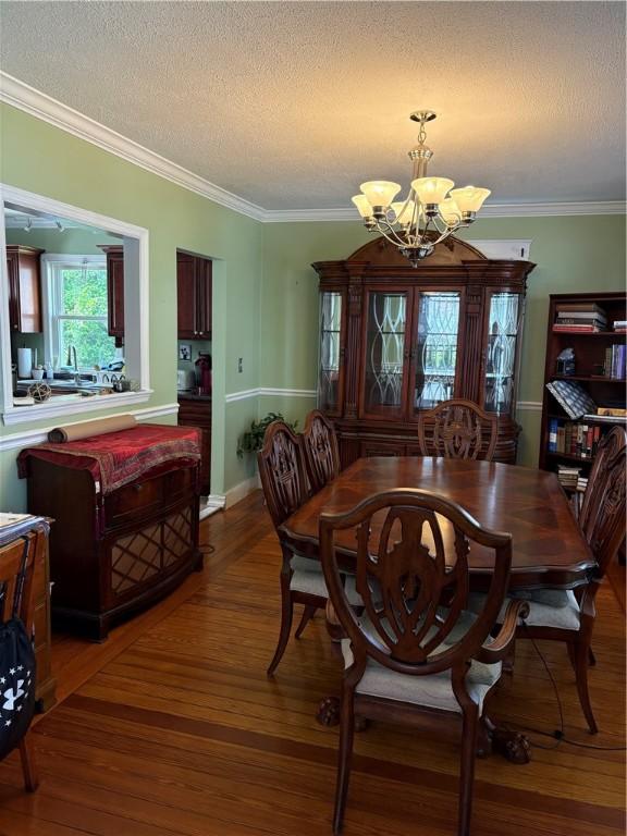 15 Villa Ave, Cranston, RI 02905 - dining room with a chandelier, wood finished floors, a textured ceiling, and crown molding