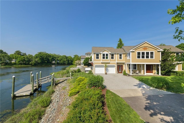 137 Congdon Ave, North Kingstown, RI 02852 - view of front of house featuring driveway, a water view, a boat dock, an attached garage, and covered porch