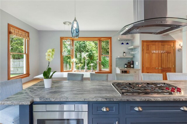137 Congdon Ave, North Kingstown, RI 02852 - kitchen featuring island exhaust hood, stainless steel gas cooktop, blue cabinetry, and light stone counters
