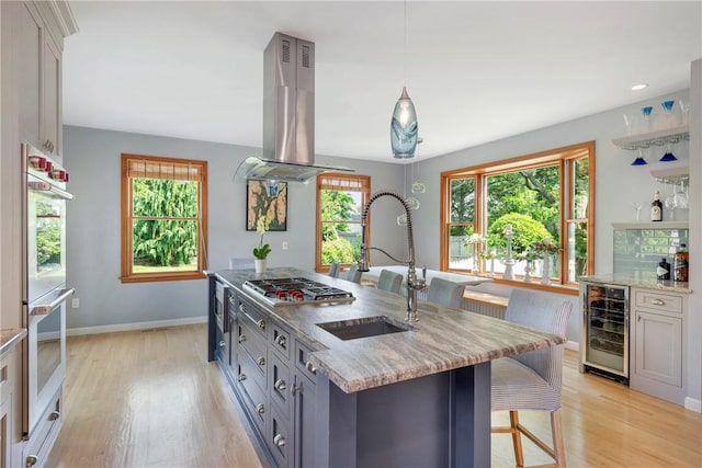 137 Congdon Ave, North Kingstown, RI 02852 - kitchen with wine cooler, island range hood, stainless steel appliances, and light wood-style floors