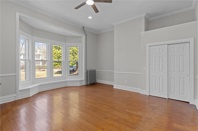 81 Old N Rd, South Kingstown, RI 02881 - unfurnished bedroom with radiator, wood finished floors, crown molding, baseboards, and ceiling fan