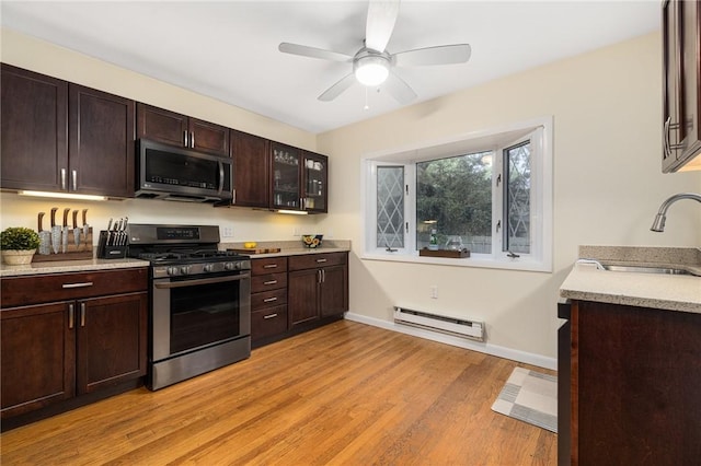 14 Twin Oak Dr, Warwick, RI 02889 - kitchen featuring appliances with stainless steel finishes, a baseboard heating unit, light wood-type flooring, light countertops, and dark brown cabinetry