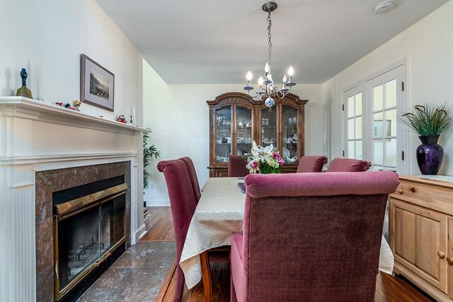 223 Corey Ln, Middletown, RI 02842 - dining space featuring a chandelier, dark wood-style flooring, and a tiled fireplace