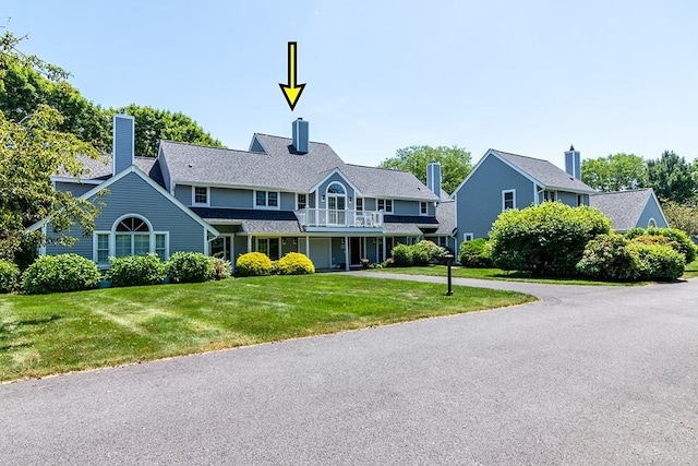 223 Corey Ln, Middletown, RI 02842 - view of front of house featuring a balcony, a front lawn, and a chimney