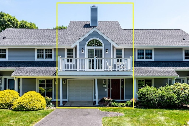 223 Corey Ln, Middletown, RI 02842 - view of property featuring a chimney, a balcony, a front lawn, an attached garage, and driveway