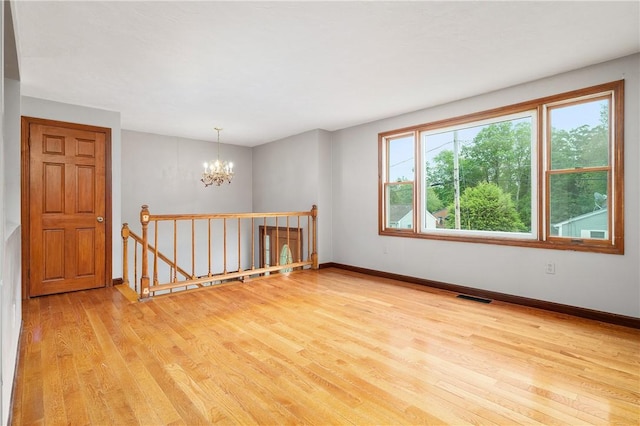21 Diana Ave, Smithfield, RI 02917 - empty room featuring a chandelier, light wood-style flooring, and baseboards