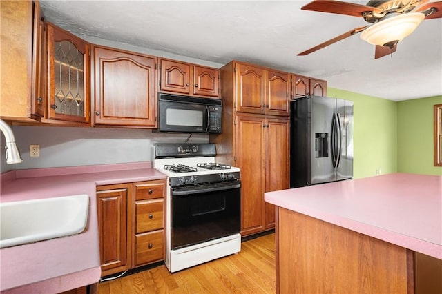 21 Diana Ave, Smithfield, RI 02917 - kitchen with black microwave, gas range oven, stainless steel fridge, and brown cabinetry