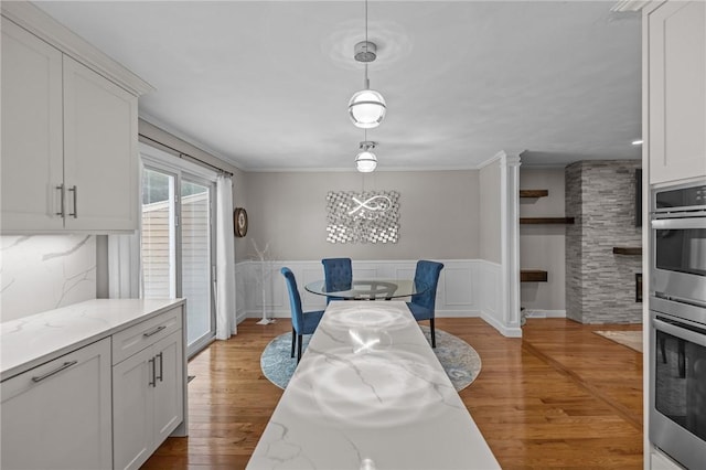 2 Tamarac Dr Unit A, Smithfield, RI 02828 - dining space featuring wainscoting, a chandelier, light wood finished floors, and crown molding