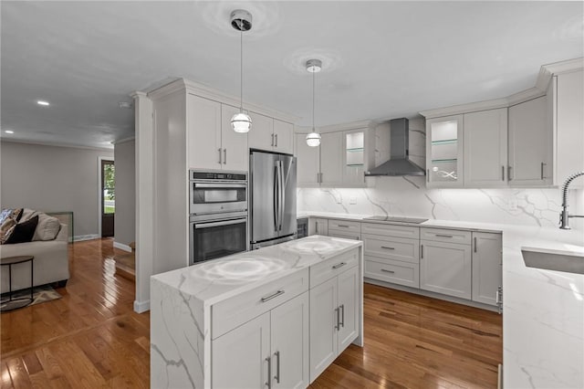2 Tamarac Dr Unit A, Smithfield, RI 02828 - kitchen featuring appliances with stainless steel finishes, wall chimney range hood, wood finished floors, a sink, and backsplash