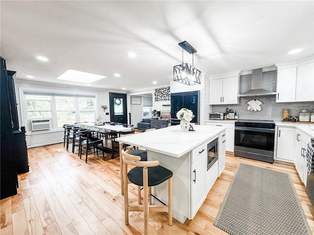 1 Sharp St, Coventry, RI 02816 - kitchen featuring wall chimney exhaust hood, black / electric stove, stainless steel microwave, a kitchen island, and white cabinets