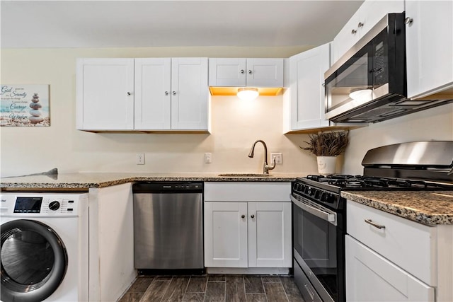 3940 Post Rd Unit 30, Warwick, RI 02886 - kitchen with appliances with stainless steel finishes, washer / dryer, a sink, wood tiled floors, and white cabinetry