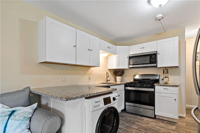 3940 Post Rd Unit 30, Warwick, RI 02886 - kitchen featuring stainless steel appliances, washer / dryer, white cabinets, and stone countertops