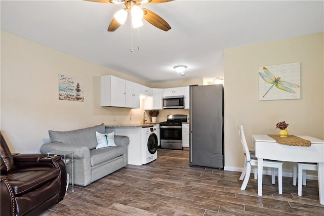 3940 Post Rd Unit 30, Warwick, RI 02886 - kitchen featuring appliances with stainless steel finishes, washer / dryer, open floor plan, dark wood finished floors, and a ceiling fan