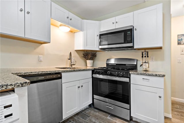 3940 Post Rd Unit 30, Warwick, RI 02886 - kitchen with stainless steel appliances, a sink, white cabinets, light stone counters, and dark wood finished floors