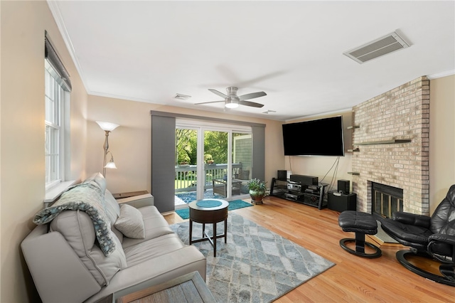 99 Post Rd Unit F1, Warwick, RI 02888 - living area with wood finished floors, ceiling fan, crown molding, and a brick fireplace