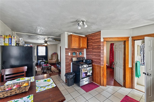 179 Armistice Blvd, Pawtucket, RI 02860 - kitchen with stainless steel appliances, light tile patterned flooring, a ceiling fan, and brown cabinetry