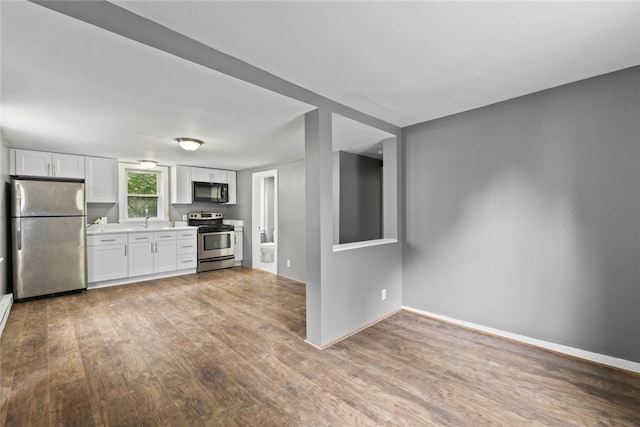 10 Sisson St, West Warwick, RI 02893 - kitchen featuring appliances with stainless steel finishes, light wood-type flooring, a sink, white cabinetry, and light countertops