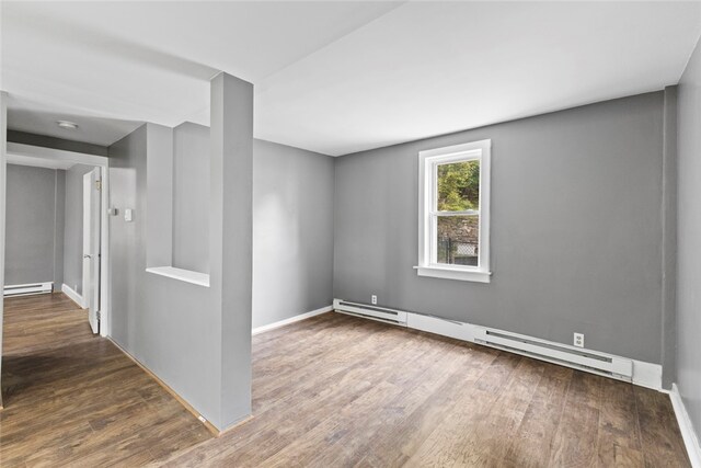 10 Sisson St, West Warwick, RI 02893 - empty room with wood finished floors, a baseboard heating unit, and baseboards