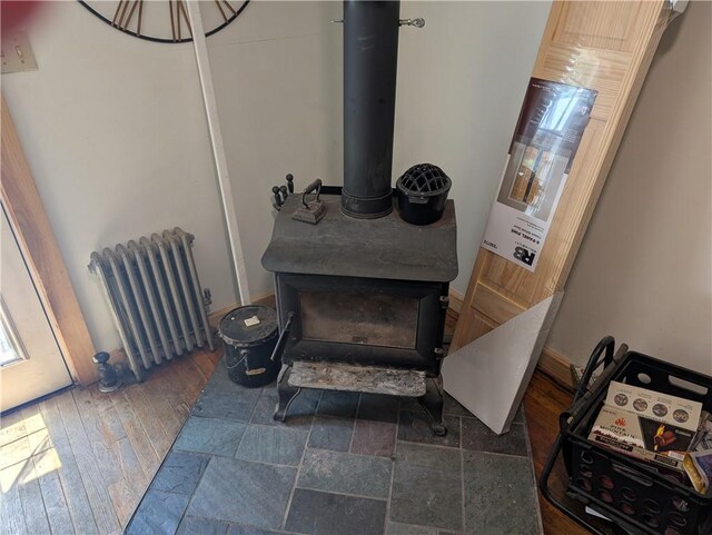 94 Mount Pleasant Rd, North Smithfield, RI 02896 - detailed view of radiator heating unit, a wood stove, and wood finished floors