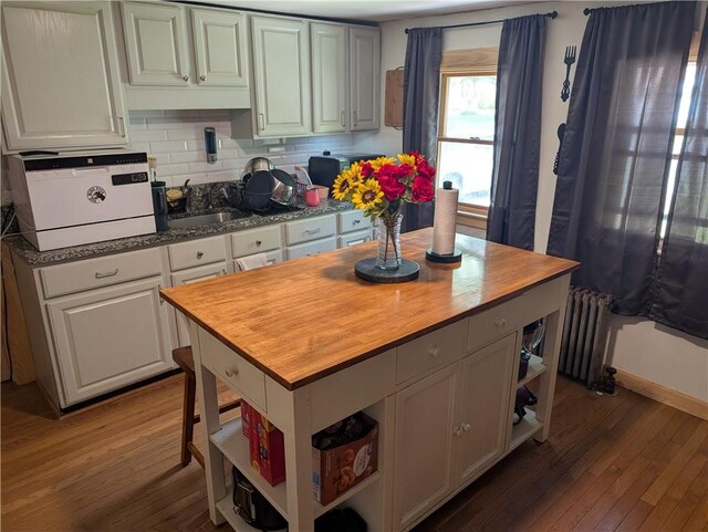 94 Mount Pleasant Rd, North Smithfield, RI 02896 - kitchen with open shelves, a sink, radiator heating unit, wood-type flooring, and butcher block counters