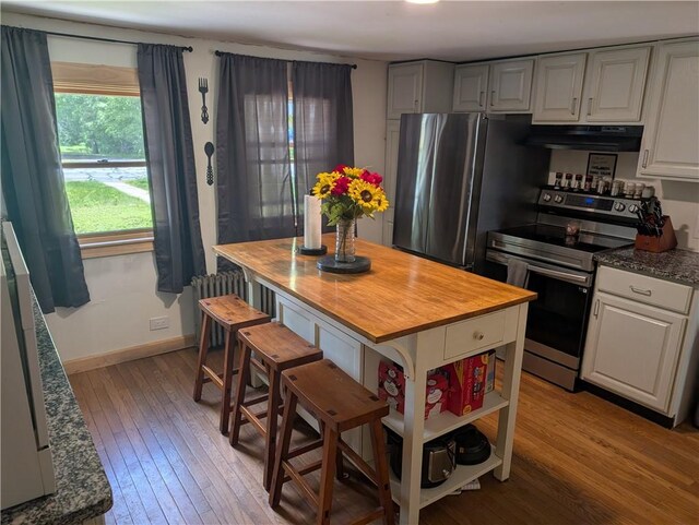 94 Mount Pleasant Rd, North Smithfield, RI 02896 - kitchen featuring appliances with stainless steel finishes, range hood, light wood finished floors, butcher block countertops, and radiator heating unit