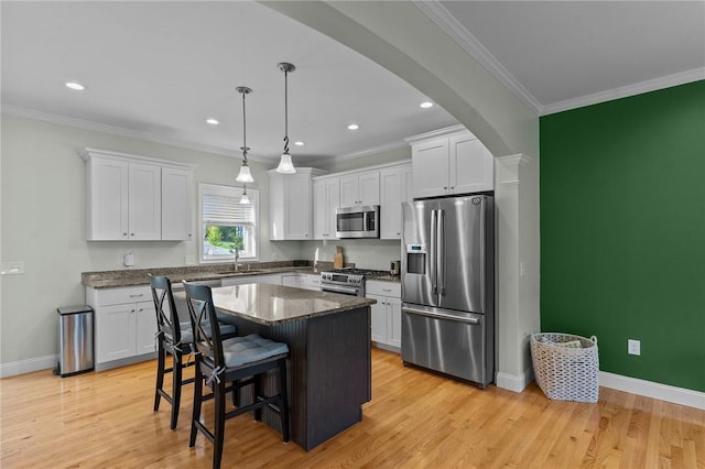 25 Ironwood Dr, Coventry, RI 02816 - kitchen featuring stainless steel appliances, white cabinetry, arched walkways, ornamental molding, and light wood-type flooring