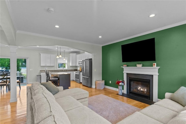 25 Ironwood Dr, Coventry, RI 02816 - living area featuring baseboards, light wood-type flooring, ornamental molding, a fireplace with flush hearth, and recessed lighting