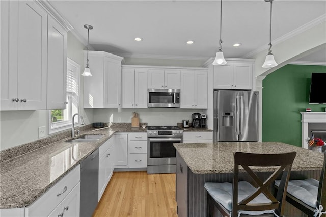 25 Ironwood Dr, Coventry, RI 02816 - kitchen with appliances with stainless steel finishes, a sink, ornamental molding, a breakfast bar, and white cabinets