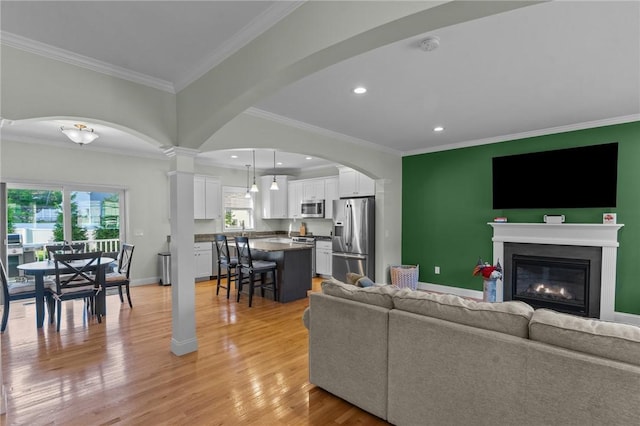 25 Ironwood Dr, Coventry, RI 02816 - living area with light wood-style flooring, a glass covered fireplace, recessed lighting, baseboards, and arched walkways
