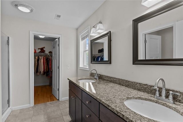 25 Ironwood Dr, Coventry, RI 02816 - bathroom featuring double vanity, a walk in closet, tile patterned flooring, baseboards, and a shower stall