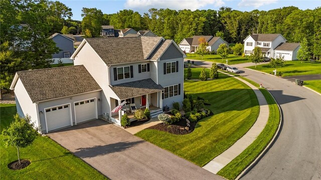 25 Ironwood Dr, Coventry, RI 02816 - traditional home featuring a porch, asphalt driveway, a garage, a residential view, and a front yard