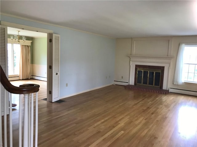 33 Red Gate Rd, Cumberland, RI 02864 - unfurnished living room with a baseboard radiator, a chandelier, wood finished floors, and crown molding