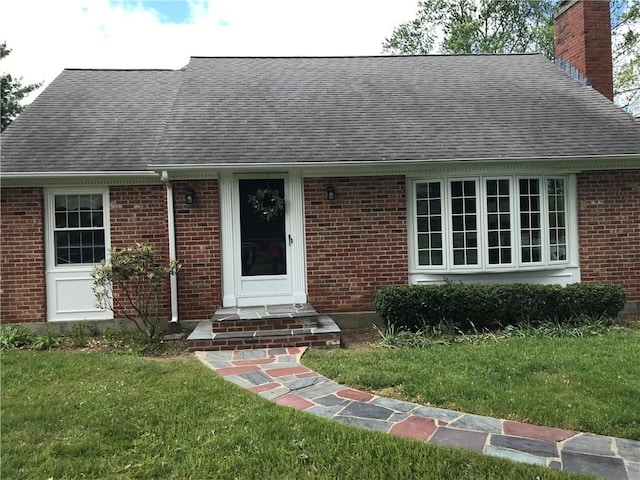 33 Red Gate Rd, Cumberland, RI 02864 - view of front of home with roof with shingles, a chimney, a front lawn, and brick siding