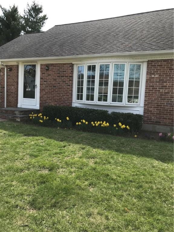33 Red Gate Rd, Cumberland, RI 02864 - view of front of property featuring a shingled roof, brick siding, and a front yard