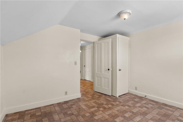 483 Dexter St, Providence, RI 02907 - additional living space with brick patterned flooring, baseboards, and vaulted ceiling
