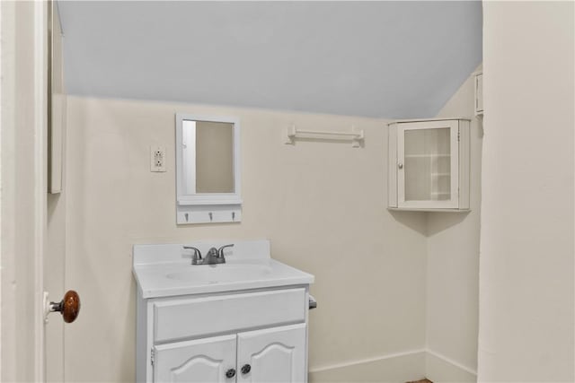 483 Dexter St, Providence, RI 02907 - bathroom with vanity, baseboards, and vaulted ceiling
