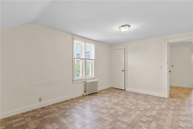 483 Dexter St, Providence, RI 02907 - additional living space with radiator heating unit, brick patterned floors, baseboards, and vaulted ceiling