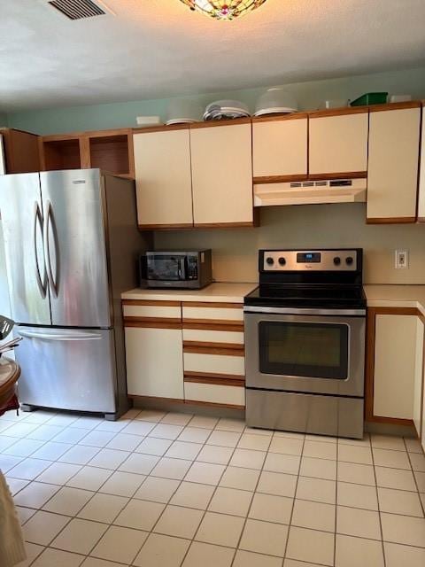 37 Trellis Dr Unit 37, West Warwick, RI 02893 - kitchen featuring stainless steel appliances, under cabinet range hood, light countertops, light tile patterned flooring, and cream cabinets