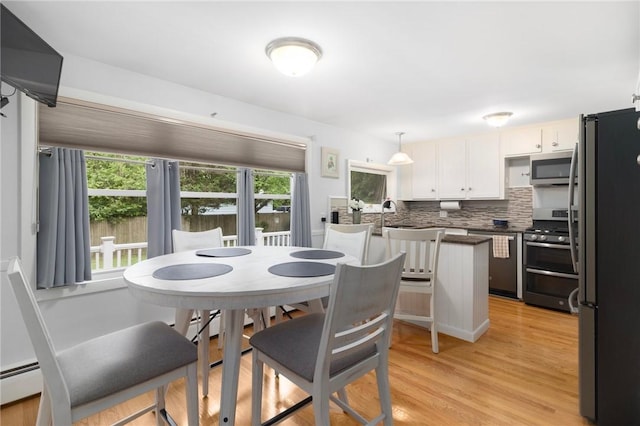 80 Flagg Ave, Warwick, RI 02886 - dining area with plenty of natural light, light wood-type flooring, and a baseboard heating unit