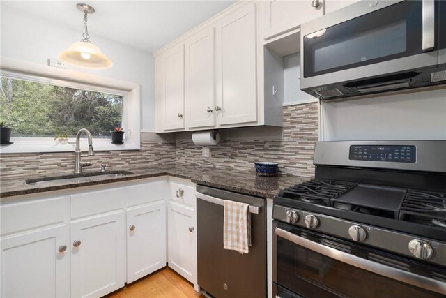80 Flagg Ave, Warwick, RI 02886 - kitchen with stainless steel appliances, a sink, tasteful backsplash, and dark stone countertops