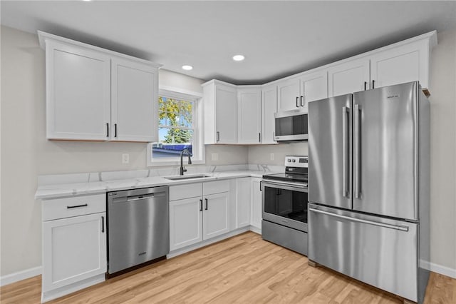 17 Judith St, Providence, RI 02909 - kitchen with stainless steel appliances, a sink, light wood finished floors, white cabinets, and recessed lighting