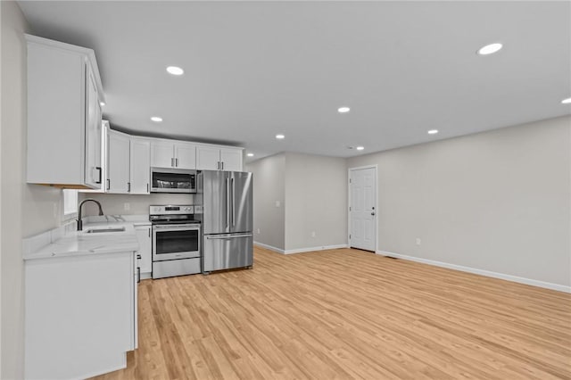 17 Judith St, Providence, RI 02909 - kitchen with stainless steel appliances, a sink, light wood-type flooring, baseboards, and recessed lighting