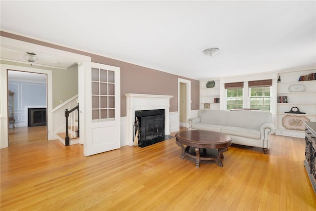 2 Carvin Ct, Warwick, RI 02886 - living area featuring a fireplace with flush hearth, built in features, stairs, light wood finished floors, and a decorative wall