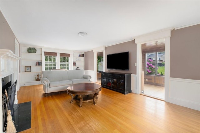 2 Carvin Ct, Warwick, RI 02886 - living area with built in features, wood finished floors, wainscoting, a fireplace with flush hearth, and ornamental molding
